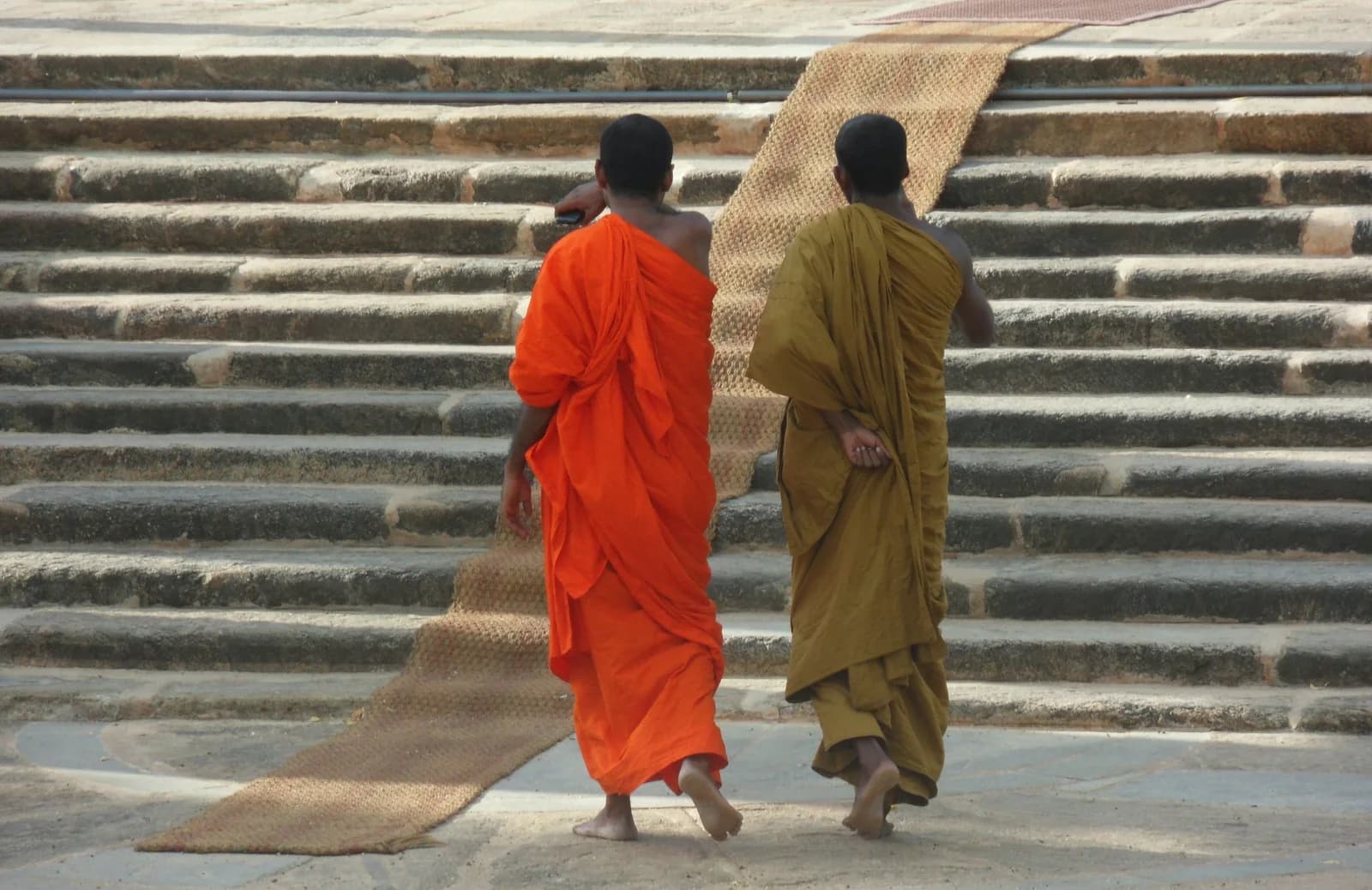 Stone steps worn smooth by pilgrims leading up to a whitewashed monastery courtyard