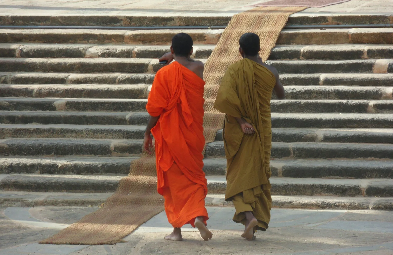Stone steps worn smooth by pilgrims leading up to a whitewashed monastery courtyard