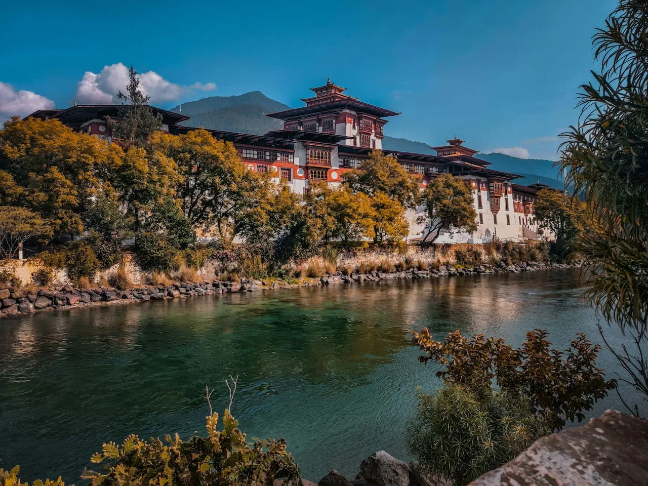 Punakha Dzong standing between the Pho Chhu and Mo Chhu rivers beneath afternoon clouds